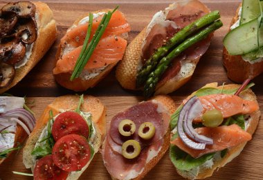 Brushetta veya geleneksel Ispanyol tapas. Italyan Antipasti aperatifler ile meze. Prosciutto ile küçük sandviç çeşitleri, kiraz domates, somon, krem peyniri, salatalık, turp, kuşkonmadan