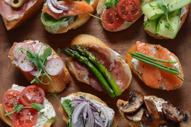 Brushetta veya geleneksel Ispanyol tapas. Italyan Antipasti aperatifler ile meze. Prosciutto ile küçük sandviç çeşitleri, kiraz domates, somon, krem peyniri, salatalık, turp, kuşkonmadan
