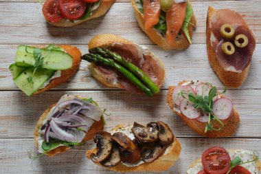 Brushetta veya geleneksel Ispanyol tapas. Italyan Antipasti aperatifler ile meze. Prosciutto ile küçük sandviç çeşitleri, kiraz domates, somon, krem peyniri, salatalık, turp, kuşkonmadan