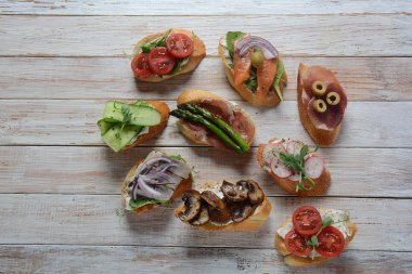 Brushetta veya geleneksel Ispanyol tapas. Italyan Antipasti aperatifler ile meze. Prosciutto ile küçük sandviç çeşitleri, kiraz domates, somon, krem peyniri, salatalık, turp, kuşkonmadan