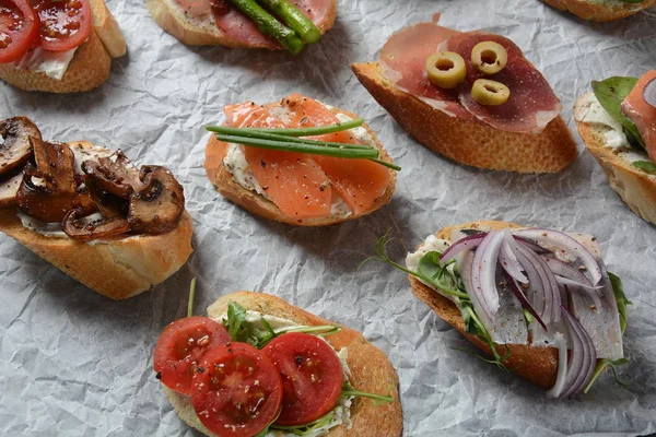 Brushetta veya geleneksel Ispanyol tapas. Italyan Antipasti aperatifler ile meze. Prosciutto ile küçük sandviç çeşitleri, kiraz domates, somon, krem peyniri, salatalık, turp, kuşkonmadan
