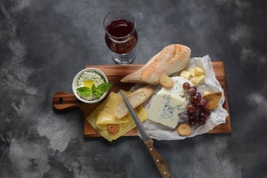 Peynir tabağı, çeşitli peynir, üzüm, koyu arka planda aperatifler. İtalyan, Fransız peynir Starter