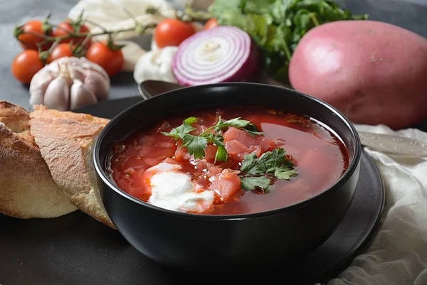 Geleneksel Ukrayna Rus borsch. Koyu arka plan üzerinde beyaz krema ile kırmızı pancar kökü çorba borsch Kase. Pancar Kökü lezzetli çorba . Geleneksel Ukrayna yemek mutfağı