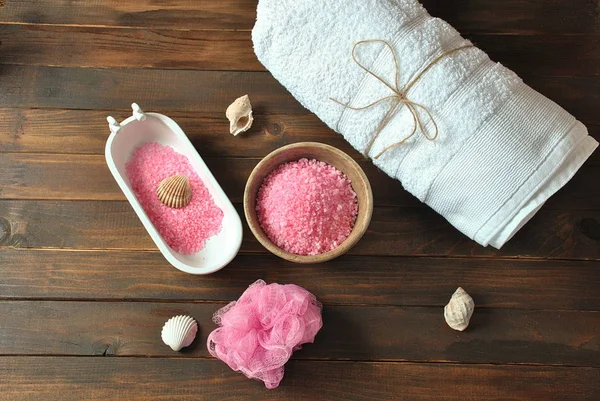 Spa and body care products. Aromatic rose bath Dead Sea Salt on the dark wooden background. Natural ingredients for homemade body salt scrub. Dead Sea cosmetics. Beauty skin care. Spa treatment.