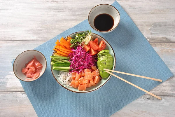 Fresh seafood recipe. Organic food. Fresh salmon poke bowl with crystal noodles, fresh red cabbage, avocado, cherry tomatoes. Food concept poke bowl -
