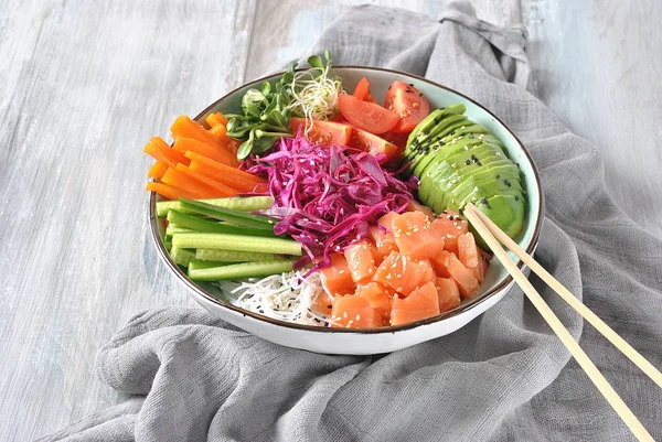 Fresh seafood recipe. Organic food. Fresh salmon poke bowl with crystal noodles, fresh red cabbage, avocado, cherry tomatoes. Food concept poke bowl -