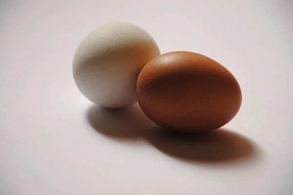 白と黒の背景に新鮮な白と茶色の卵 — ストック写真