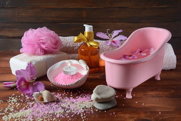 Spa and body care products. Aromatic rose bath Dead Sea Salt on the dark wooden background. Natural ingredients for homemade body salt scrub. Dead Sea cosmetics. Beauty skin care. Spa treatment