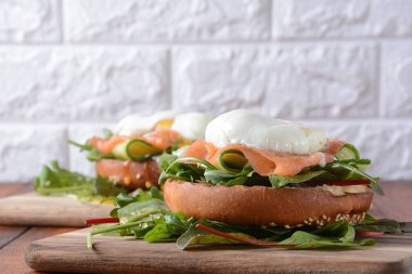 Yeşil salatalık ile haşlanmış yumurta, arugula pancar yaprakları, bir tost, ahşap arka plan üzerinde somon ve baharat füme. Sağlıklı Fransız kahvaltı konsepti