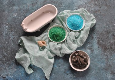 Spa ve vücut bakım konsepti. Renkli, aromatik banyo tuzu. Ölü Deniz Karadeniz Çamuru. Renkli tuz arka planda deniz kabuğu. Ölü Deniz kozmetikleri. Ev yapımı vücut tuzu fırçalamak için doğal maddeler. Cilt bakımı, spa tedavisi, güzellik ve sağlık konsepti