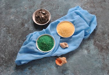 Spa ve vücut bakım konsepti. Renkli, aromatik banyo tuzu. Ölü Deniz Karadeniz Çamuru. Renkli tuz arka planda deniz kabuğu. Ölü Deniz kozmetikleri. Ev yapımı vücut tuzu fırçalamak için doğal maddeler. Cilt bakımı, spa tedavisi, güzellik ve sağlık konsepti