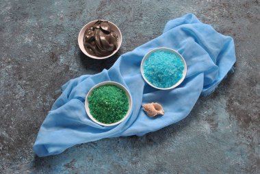 Spa ve vücut bakım konsepti. Renkli, aromatik banyo tuzu. Ölü Deniz Karadeniz Çamuru. Renkli tuz arka planda deniz kabuğu. Ölü Deniz kozmetikleri. Ev yapımı vücut tuzu fırçalamak için doğal maddeler. Cilt bakımı, spa tedavisi, güzellik ve sağlık konsepti