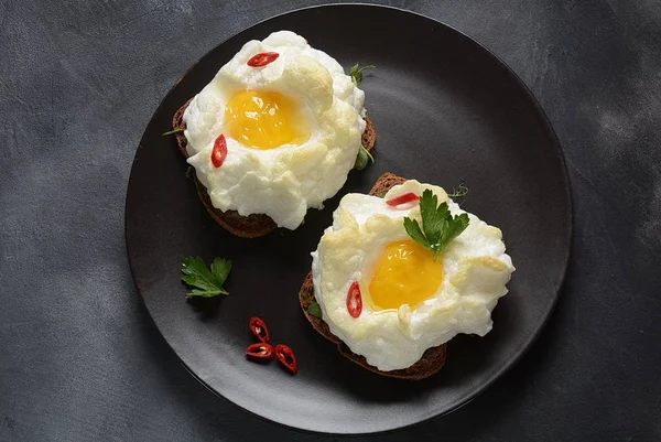 Delicate baked egg. Orsini eggs in the cloud. French breakfast.Cloud egg on toast