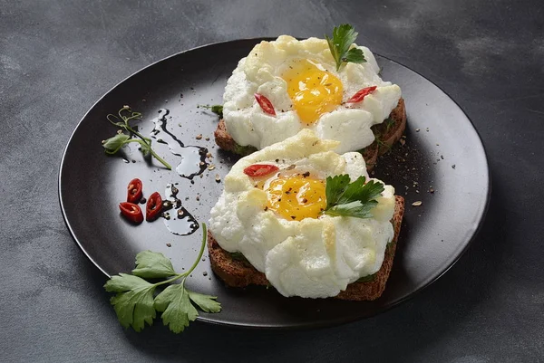 Delicate baked egg. Orsini eggs in the cloud. French breakfast.Cloud egg on toast