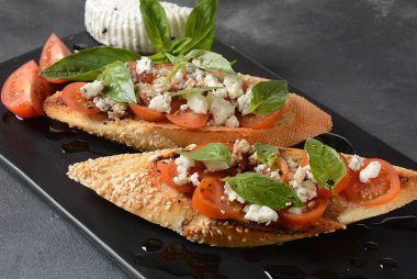 Kiraz domates, mozzarella ve fesleğen ile Caprese bruschetta tost. İtalyan antipasti atıştırmalıkları ile mezeler. 