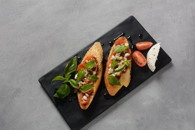 Kiraz domates, mozzarella ve fesleğen ile Caprese bruschetta tost. İtalyan antipasti atıştırmalıkları ile mezeler. 