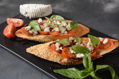 Kiraz domates, mozzarella ve fesleğen ile Caprese bruschetta tost. İtalyan antipasti atıştırmalıkları ile mezeler. 