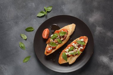 Kiraz domates, mozzarella ve fesleğen ile Caprese bruschetta tost. İtalyan antipasti atıştırmalıkları ile mezeler. 