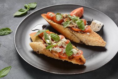 Kiraz domates, mozzarella ve fesleğen ile Caprese bruschetta tost. İtalyan antipasti atıştırmalıkları ile mezeler. 