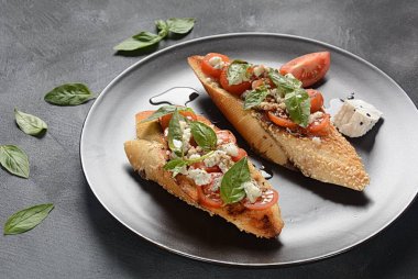 Kiraz domates, mozzarella ve fesleğen ile Caprese bruschetta tost. İtalyan antipasti atıştırmalıkları ile mezeler. 