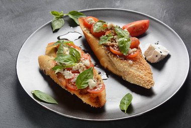 Kiraz domates, mozzarella ve fesleğen ile Caprese bruschetta tost. İtalyan antipasti atıştırmalıkları ile mezeler. 