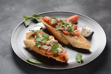 Kiraz domates, mozzarella ve fesleğen ile Caprese bruschetta tost. İtalyan antipasti atıştırmalıkları ile mezeler. 