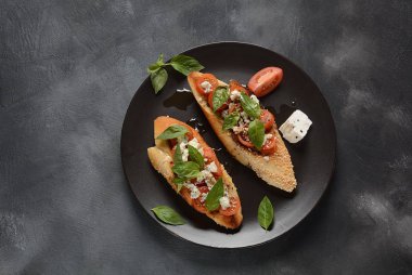 Kiraz domates, mozzarella ve fesleğen ile Caprese bruschetta tost. İtalyan antipasti atıştırmalıkları ile mezeler. 