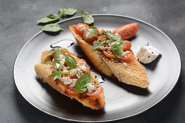 Kiraz domates, mozzarella ve fesleğen ile Caprese bruschetta tost. İtalyan antipasti atıştırmalıkları ile mezeler. 