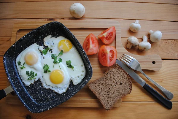 在平底锅中煎鸡蛋 在木制背景上享用早餐 包括西红柿和面包 美味健康的自制早餐理念 — 图库照片