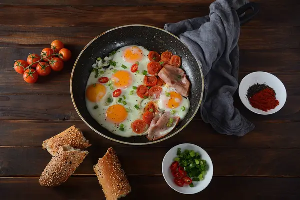 煎蛋在平底锅与樱桃西红柿 培根和面包早餐在木制背景 美味早餐理念 — 图库照片