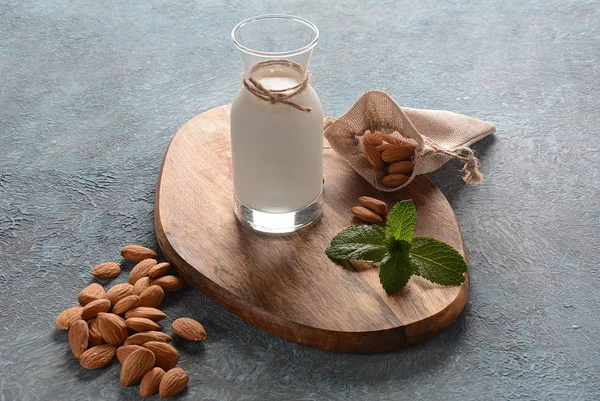 Almond milk in glass bottles with almonds on background. Vegan diary concept. Healthy food and drinks