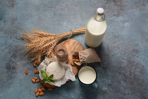 Almond milk in glass bottles with almond nuts on background. Vegan diary concept. Shavuot Jewish holiday food concept - dairy products and wheat , copy space