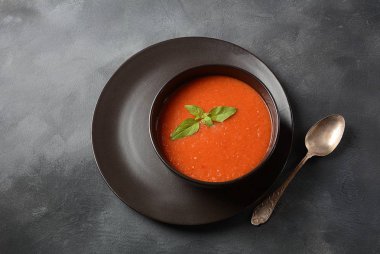 Biber ve sarımsak, fesleğen ile Domates gazpacho çorbası. İspanyol mutfağı. Koyu arka plan üzerinde siyah bir kapta Domates soğuk çorba