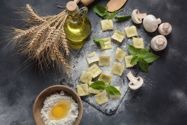 Mantar, fesleğen, un, buğday, koyu arka plan üzerinde zeytinyağı ile İtalyan çiğ ravioli. Shavuot Yahudi tatil gıda kavramı