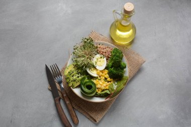 Haşlanmış yumurta, avokado, mısır, arugula pancar yaprakları, taze salatalık, karabuğday, brokoli filizi ile Yeşil vejetaryen Buda kase öğle yemeği. Sağlıklı vegan gıda konsepti 
