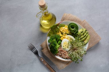 Haşlanmış yumurta, avokado, mısır, arugula pancar yaprakları, taze salatalık, karabuğday, brokoli filizi ile Yeşil vejetaryen Buda kase öğle yemeği. Sağlıklı vegan gıda konsepti 