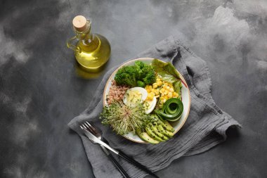 Haşlanmış yumurta, avokado, mısır, arugula pancar yaprakları, taze salatalık, karabuğday, brokoli filizi ile Yeşil vejetaryen Buda kase öğle yemeği. Sağlıklı vegan gıda konsepti 