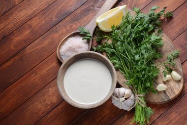 Tahta arka plan üzerinde maydanoz ile kase de susam yapılmış tahin sosu