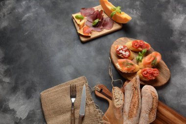 Brushetta veya geleneksel İspanyol tapas. İtalyan antipasti atıştırmalıkları ile mezeler. Kiraz domates, somon, krem peynir ile küçük sandviç çeşitleri. Prosciutto kavun ve fesleğen ile servis