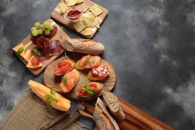 Brushetta veya geleneksel İspanyol tapas. İtalyan antipasti atıştırmalıkları ile mezeler. Kiraz domates, somon, krem peynir ile küçük sandviç çeşitleri. Prosciutto kavun ve fesleğen ile servis
