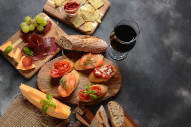 Brushetta veya geleneksel İspanyol tapas. İtalyan antipasti atıştırmalıkları ile mezeler. Kiraz domates, somon, krem peynir ile küçük sandviç çeşitleri. Prosciutto kavun ve fesleğen ile servis
