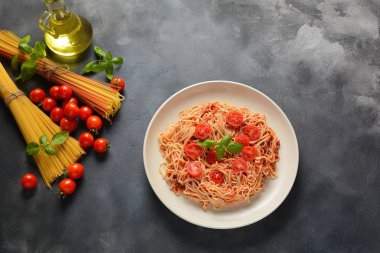 Koyu masa üzerinde plaka üzerinde domates sosu ve fesleğen ile klasik Italyan spagetti makarna 