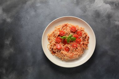 Koyu masa üzerinde plaka üzerinde domates sosu ve fesleğen ile klasik Italyan spagetti makarna 