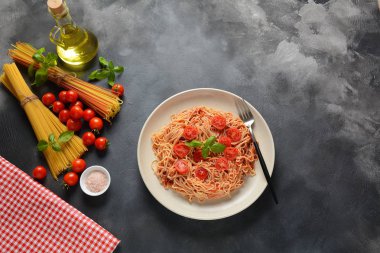 Koyu masa üzerinde plaka üzerinde domates sosu ve fesleğen ile klasik Italyan spagetti makarna 