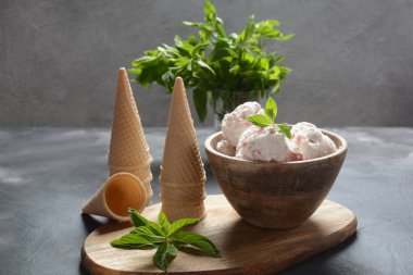 Dondurma ve waffle konileri. Ahşap bir kase içinde dondurma, nane yaprakları ile 