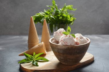 Dondurma ve waffle konileri. Ahşap bir kase içinde dondurma, nane yaprakları ile 