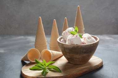 Dondurma ve waffle konileri. Ahşap bir kase içinde dondurma, nane yaprakları ile 