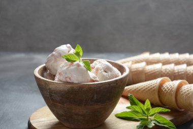 Dondurma ve waffle konileri. Ahşap bir kase içinde dondurma, nane yaprakları ile 