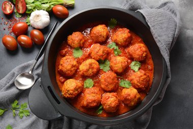 Baharat ile tatlı ve ekşi Domates sosu köfte koyu arka planda bir kızartma tavasında hizmet vermiştir. Üst görünüm 