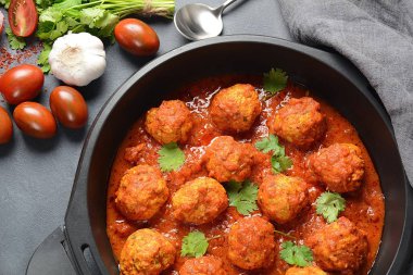 Baharat ile tatlı ve ekşi Domates sosu köfte koyu arka planda bir kızartma tavasında hizmet vermiştir. Üst görünüm 